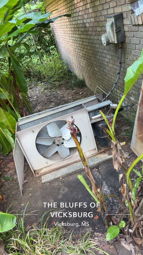 Old rusted outdoor A/C unit with its panels falling off, Vicksburg